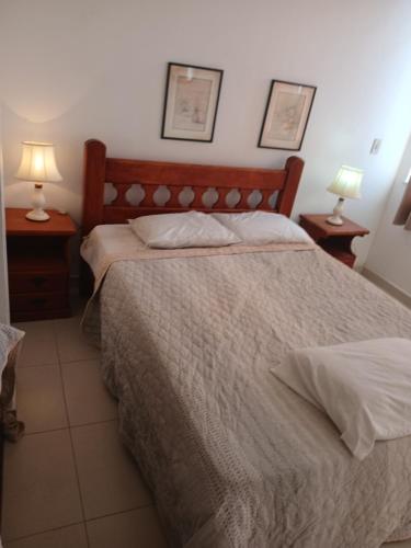 a bedroom with a bed and two lamps on tables at Apartamento in Cabo Frio