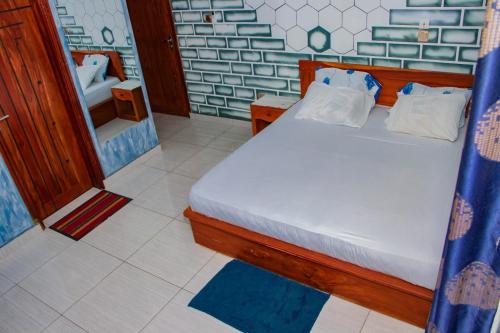 a bedroom with a bed in a room with a mirror at ODG Cotonou - Résidences Océan De Grâce in Cotonou
