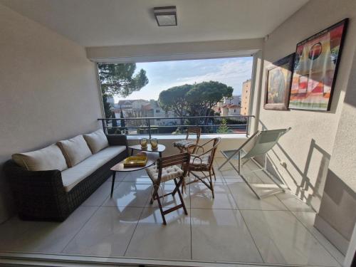 un salon avec un canapé, une table et des chaises dans l'établissement Grand 3 chambres quartier Pinède Juan, à Antibes