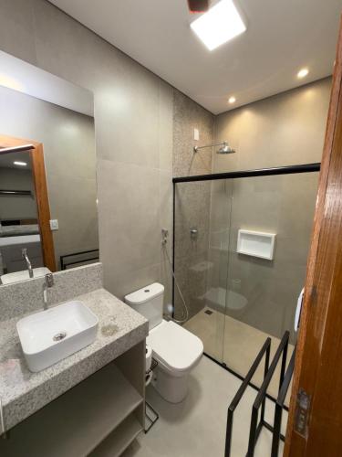 a bathroom with a toilet and a sink and a shower at Smart Suítes Trancoso in Porto Seguro