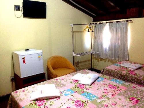 um quarto com duas camas e uma televisão num quarto em Village Pendotiba em Niterói