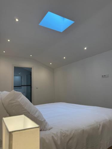 - une chambre avec un lit blanc et un plafond bleu dans l'établissement UNIQUE - Rez de jardin neuf - 10 min du Palais des Festivals, à Cannes