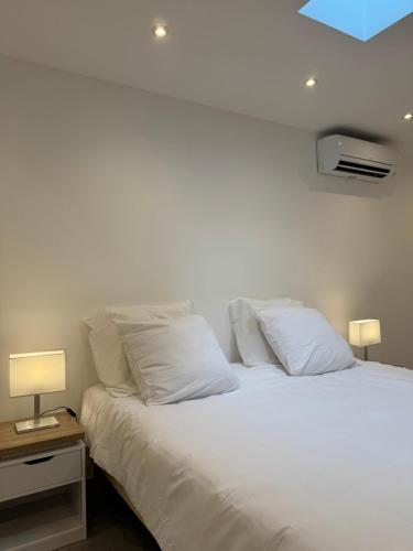 - un lit blanc avec des oreillers blancs et un plafond bleu dans l'établissement UNIQUE - Rez de jardin neuf - 10 min du Palais des Festivals, à Cannes