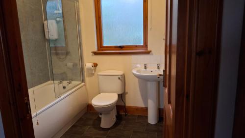 a bathroom with a toilet and a sink and a shower at Taigh Na Talia - 2 Sandholm in Mallaig