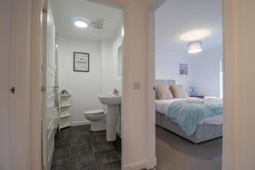a bedroom with a bed and a sink and a toilet at Lendrick House-Spacious 3 Bed House in Falkirk in Polmont