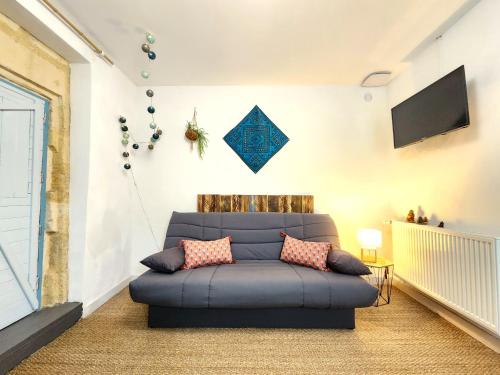 un salon avec un canapé bleu et une télévision dans l'établissement Studio de la Rivière, à Libourne