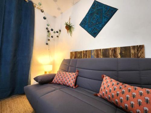 un salon avec un canapé bleu avec des oreillers dans l'établissement Studio de la Rivière, à Libourne