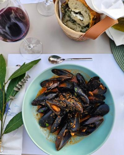 a plate of mussels on a table with a bowl of bread at Boutique Resort OSMA - Adults Only in Malinska