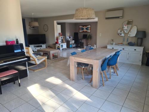 - un salon avec une table, des chaises et un piano dans l'établissement Beautiful villa with pool, à Baillargues