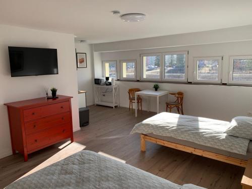 a bedroom with two beds and a tv and a table at Seenland Fewo - 5 in Fürstenberg-Havel
