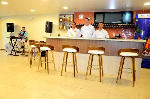 a group of men standing at a bar at Mediterrane Hotel by Castelo Itaipava in Arraial do Cabo