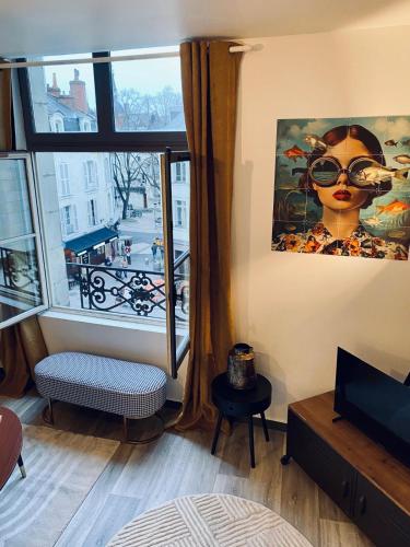 Cette chambre dispose d'une grande fenêtre offrant une vue sur la ville. dans l'établissement Le Cinq, Appartement de charme Place Saint Pierre Saumur, à Saumur
