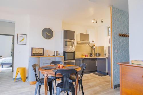 une cuisine avec une table et des chaises dans une pièce dans l'établissement Le Cinq, Appartement de charme Place Saint Pierre Saumur, à Saumur