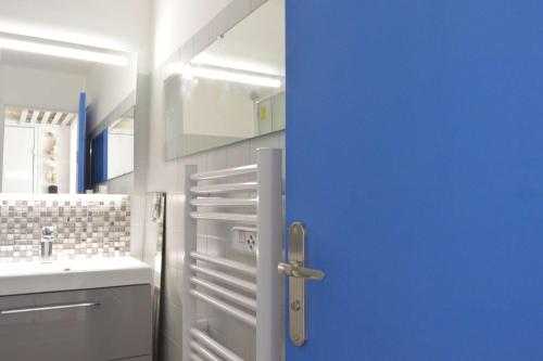 La salle de bains est pourvue d'une porte bleue et d'un lavabo. dans l'établissement Appt Studio cabine 4 couchages CAP D'AGDE CT455-137, au Cap d'Agde