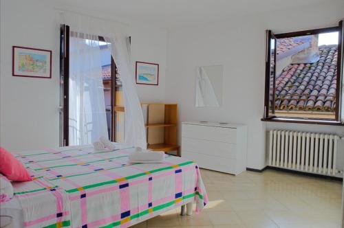 a white room with a bed and a window at Casa Gialla Soggiorno Panorama in Centro Storico in Dogliani