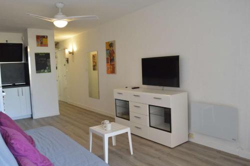 - un salon avec une télévision sur une commode blanche dans l'établissement Appt Studio cabine 4 couchages CAP D'AGDE CT455-137, au Cap d'Agde