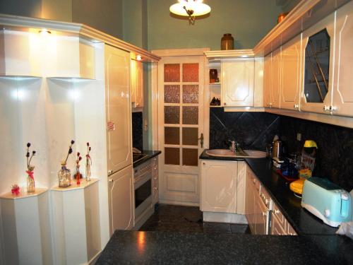 a kitchen with white cabinets and black counter tops at Pefkakia Park in Ermoupoli
