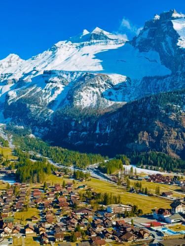 a village in front of a mountain with snow at Cute & cozy oasis, private afternoon sun terrace in Kandersteg