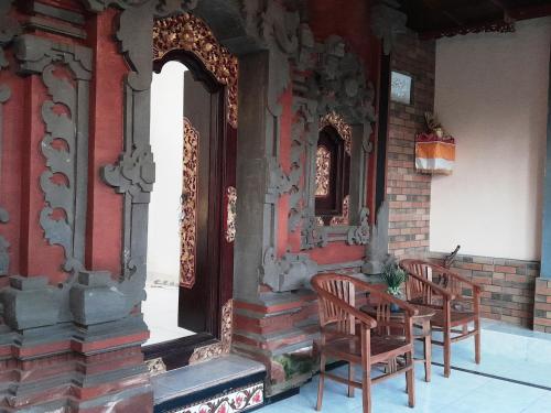 a group of chairs and a table outside of a building at Pondok Dauh Ancak Kelating Guest House in Krambitan