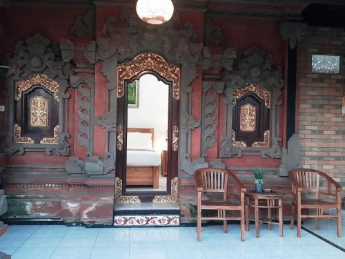 an entrance to a room with two chairs and a bed at Pondok Dauh Ancak Kelating Guest House in Krambitan