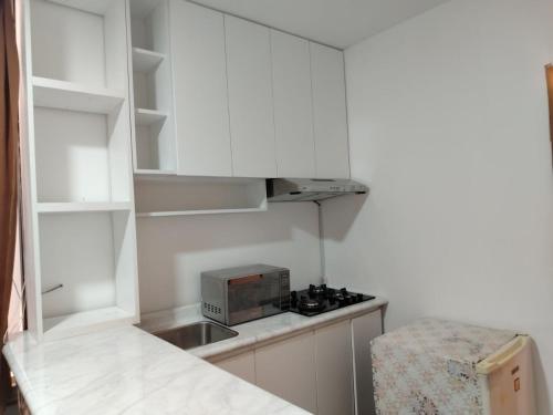 a small kitchen with white cabinets and a microwave at Casa Solé in Lima