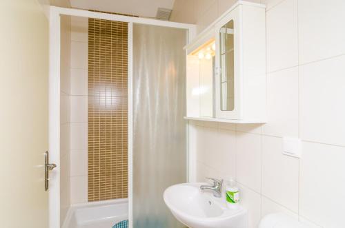 un bagno bianco con lavandino e doccia di Chic Apartment with Sea View in Dubrovnik - 48 sqm a Dubrovnik