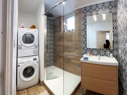 une salle de bain avec une machine à laver et un lavabo dans l'établissement T3 clim, TV, ART, familial, 50m du port, cuisine équipée et jeux de société, à Port-Vendres