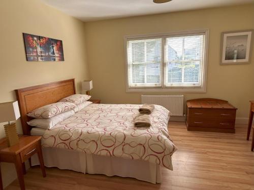 a bedroom with a bed and a table and a window at Number 7 Bank House in Schull