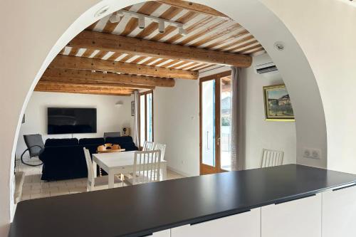 une cuisine et un salon avec un comptoir noir dans l'établissement L'Isle en coeur air-conditioned house with garden and swimming pool, à LʼIsle-sur-la-Sorgue