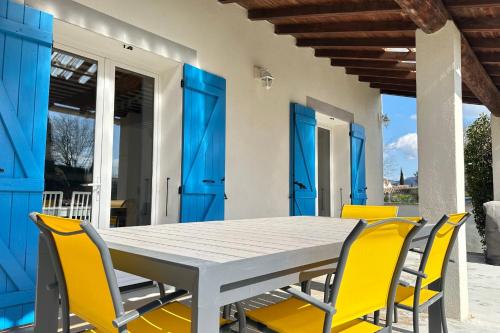 une table à manger et des chaises avec des portes bleues dans l'établissement L'Isle en coeur air-conditioned house with garden and swimming pool, à LʼIsle-sur-la-Sorgue