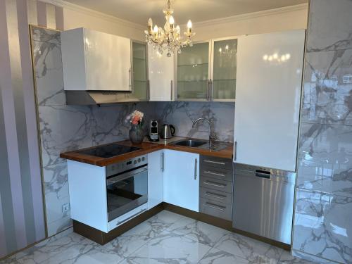 a kitchen with white appliances and a chandelier at Classico Uno in Meckenbeuren