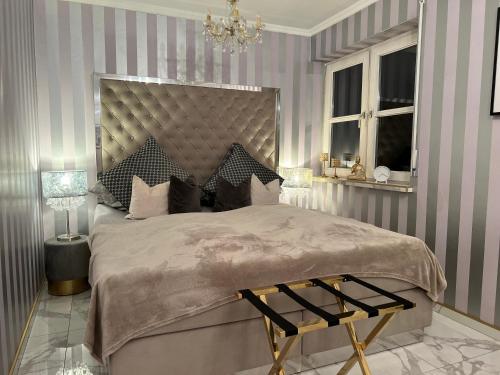 a bedroom with a large bed and a chandelier at Classico Uno in Meckenbeuren
