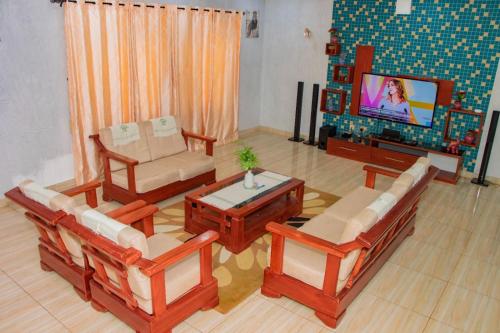 a living room with wooden furniture and a tv at ODG Cotonou - Résidences Océan De Grâce in Cotonou