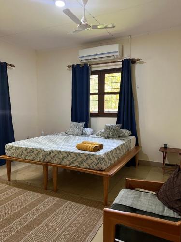 a bedroom with a large bed with blue curtains at Kivuli Lodge in Moshi
