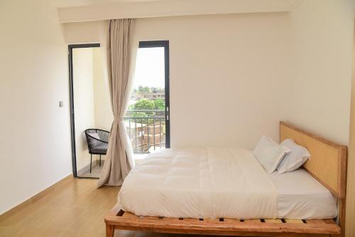a bedroom with a large bed with a window at A Minimalist Haven 10 mins from UN avenue in Ruaka