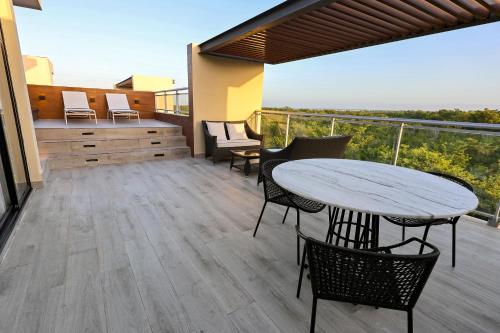 a patio with a table and chairs on a balcony at 404 y 504 Luxurious PH with Jacuzzi near the Beach in La Laguna