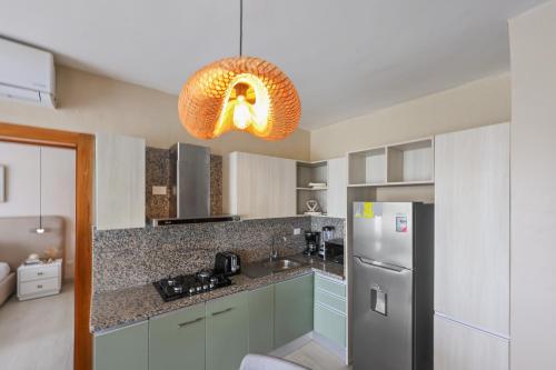 a kitchen with a refrigerator and a light fixture at 404 y 504 Luxurious PH with Jacuzzi near the Beach in La Laguna