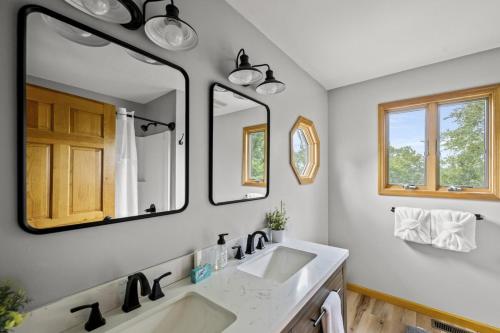 un bagno con due lavandini e due specchi di High Top Cabin in the Smokies a Sevierville