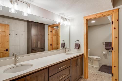 a bathroom with a sink and a toilet and a mirror at Sprawling Minnesota Home with On-Site Lake Access in Lake Shore