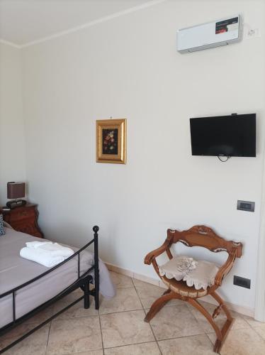 a bedroom with a bed and a chair and a television at casa stefano in Piumarola