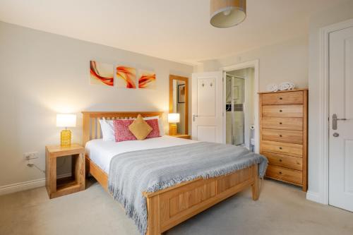 a bedroom with a bed and a dresser at Comfy & stylish 4 bed house in Bedford