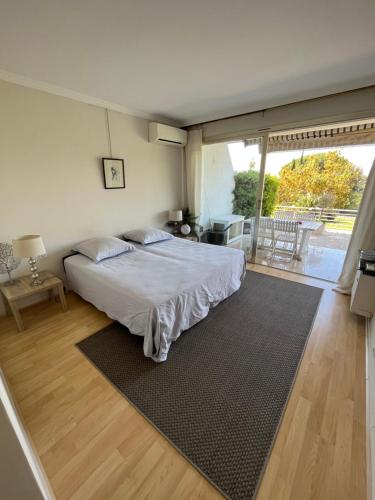 une chambre avec un lit et une grande fenêtre dans l'établissement Appt Croix des Gardes Piscine 5 Mn plage, à Cannes