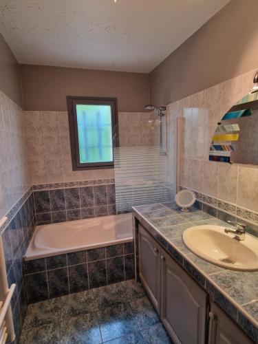 a bathroom with a tub and a sink at Chambre d'hôtes in Saint-Martial-de-Valette