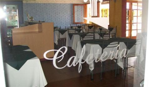 a restaurant with tables and chairs and a sign that says cafeteria at Hotel La Posta del Dayman in Termas del Daymán