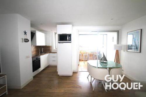 une cuisine avec une table en verre et une cuisine avec une fenêtre dans l'établissement Appartement 4 personnes avec vue mer, à Canet