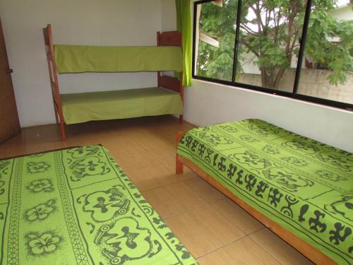 Cette chambre comprend 2 lits et une fenêtre. dans l'établissement LA CABAÑA IDEAL PARA FAMILIAS DE 6 a 12 PERSONAS!, à Hanga Roa