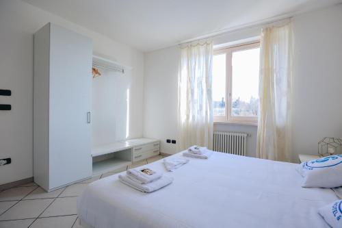 biała sypialnia z dwoma łóżkami i oknem w obiekcie Residenza Pastrengo w mieście Pastrengo