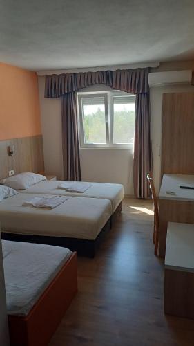 a hotel room with two beds and a window at Casa Bevanda in Međugorje