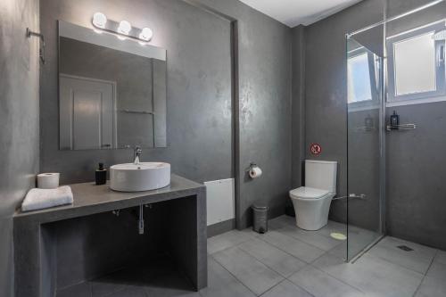 a bathroom with a sink and a shower and a toilet at Boutique Studios & Apartments - by Avelink in Spáta