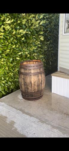 a wooden barrel sitting in front of a bush at 1 Gullion Lodge Newry in Newry
